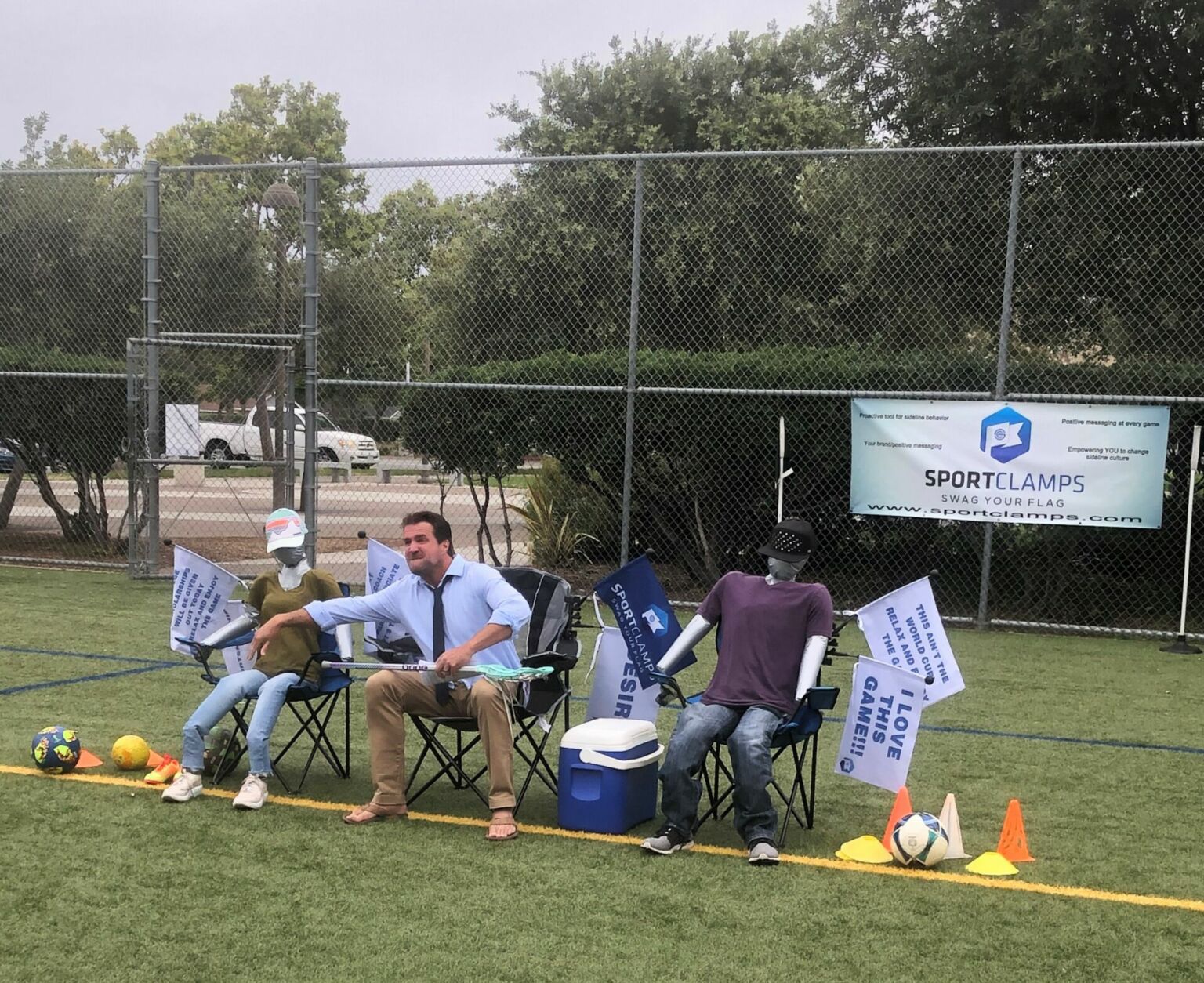 The SportClamps founder demonstrating flag displays beside a youth soccer field